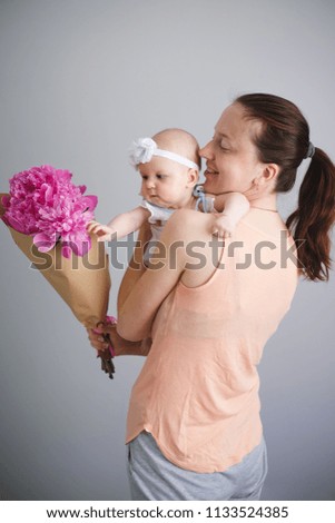 Dad presented a ping flowers bouquet for a mother with a newborn baby. Happy young family