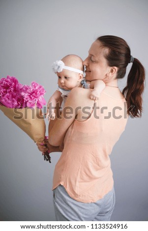 Happy young family. Mother and her daughter glad of flowers bouquet