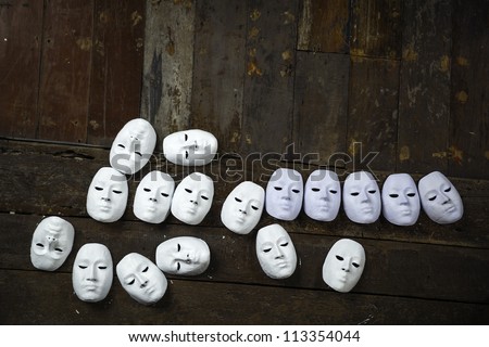 Abstract white masks on wooden background Royalty-Free Stock Photo #113354044