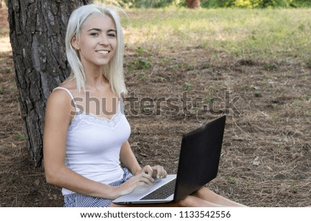 young girl in the field with laptop