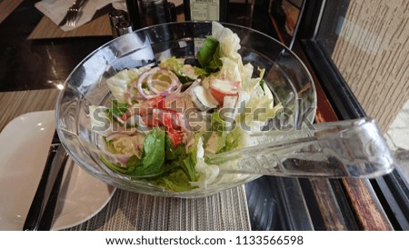 Fresh Garden Salad on a plastic bowl atop a table resto.