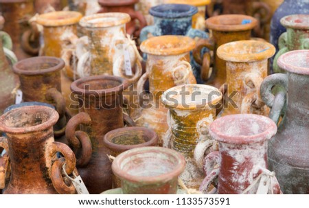 Colorful handmade terra-cotta water jugs for sale on a southwestern street market