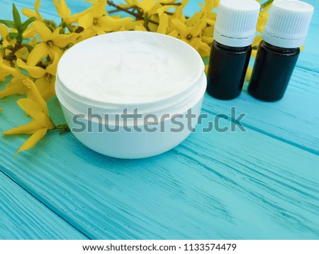 cream cosmetic yellow flowers on a wooden background