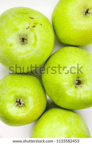 Green apple is lying  on a white background