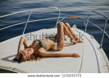 Pretty young woman relaxing on the yacht at sea