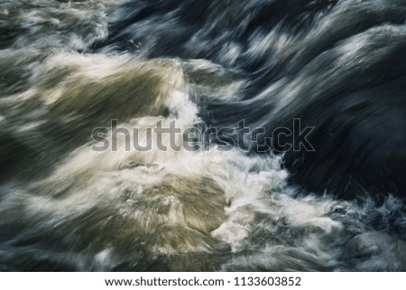 abstract nature background dark ripples on a wild river