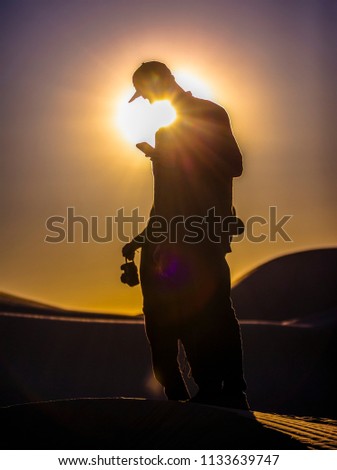 Man using phone in sand dunes