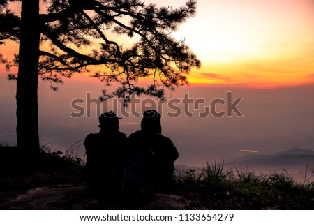 Couple on the mountain with sunset.