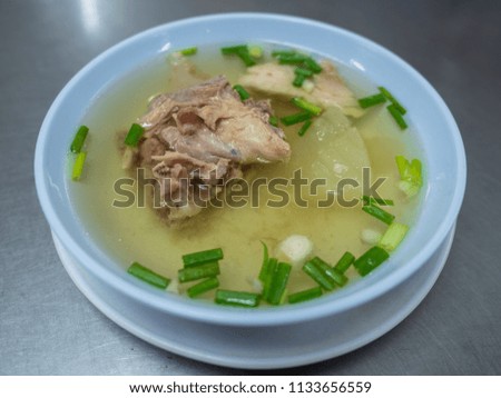 a bowl of chicken broth with herbs and Chicken bone