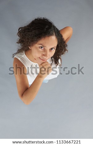Young woman with thinking look isolated on gray background above top view