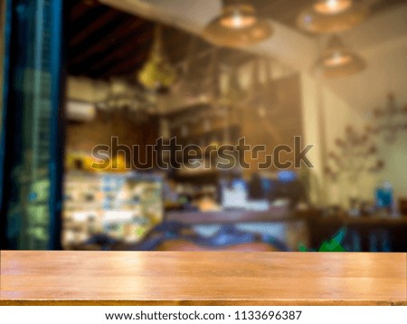 Brown wooden desk blurred coffee shop background.