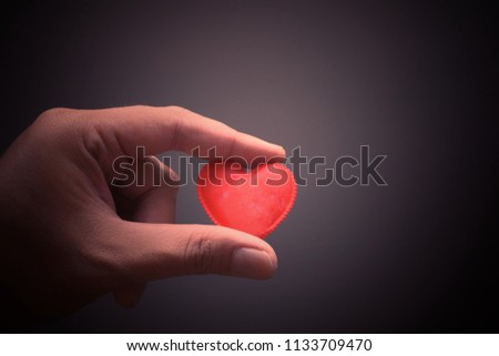 Hand holding the red heart symbol. Soft and vintage background image.