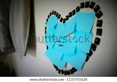 Heart with paper word what is love on wall