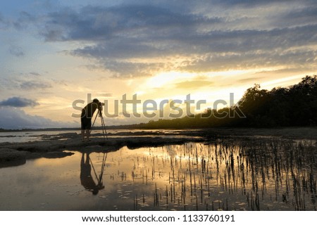 Silhouette photographer standing shoot sunset landscape