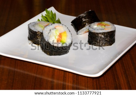 Nori seaweed roll on the outside, filled with fish and / or vegetables. y/o vegetales.