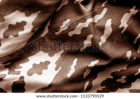 Military uniform pattern with blur effect in brown tone. Abstract background and texture.