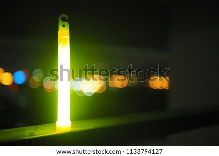 Yellow glow stick with bokeh night city background