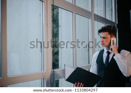 Businessman talking on phone with client, checking agenda.man speaking by phone.