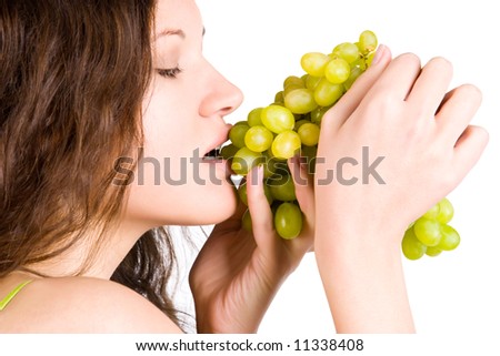 Young woman eating grapes. Isolated on white.
