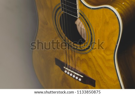 details of acoustic guitars are photographed close on dark background