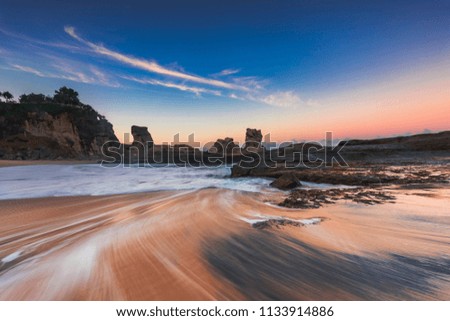Long exposure of beautiful Klayar beach, Pacitan, East Java, Indonesia. Showing wave motion blur effect with beautiful blue sky and golden hours sky before sunrise