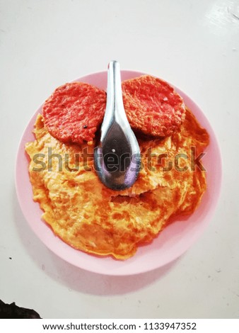 Rice with omelette in a pink plate on a white table. fried beaten eggs, omelet
