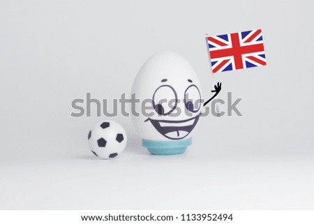 comedy football. funny and funny football player. emotional fan. on a white background. an egg with a face. happy egg looks at a soccer ball with the flag of england