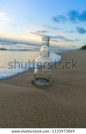 Glass bottle with beatiful beach sunset landscape