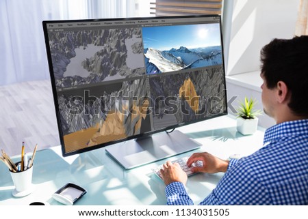 Creative designer editing 3D llndscape in software on computer in office