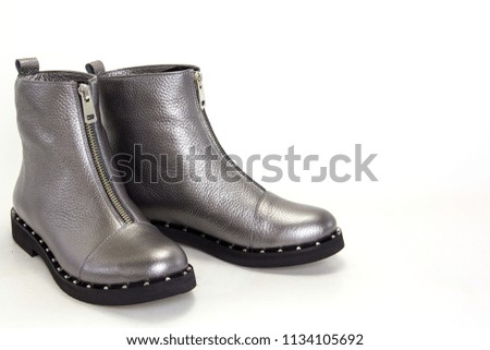 A pair of gray leather women's boots with a zipper on a white (isolated) background