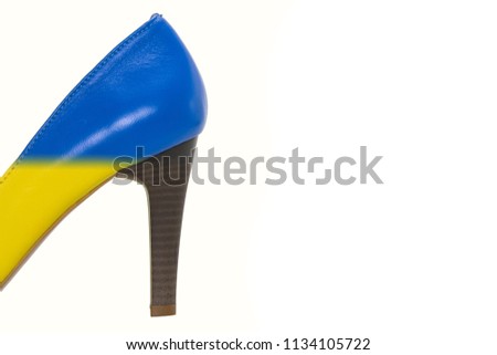 Photo of a heel of blue and yellow (the colors of the Ukrainian flag) of leather women's shoes isolated on a white background.