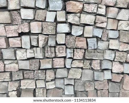 Colored small-rowed stone mosaics wall background.