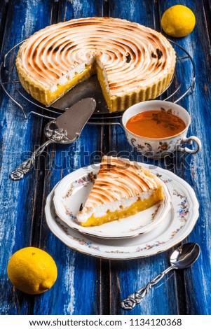 Lemon tart with meringue topping on a wooden blue table board