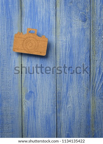 Camera on a wooden background. Wooden toy camera on a blue wooden background. Hobby.