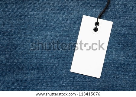 Blank tag over denim background with copy space