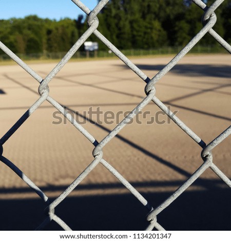 Chain link fence at the baseball field.  Evening shadow