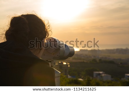 A girl looks through panoramic binoculars on a viewing platform Royalty-Free Stock Photo #1134211625