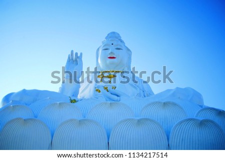 Low angle view of THE GODDESS OF COMPASSION AND MERCY Statue (Quan Yin / Guan Yin / Guan Yim statue) with clear blue sky at Chiang rai Thailand.