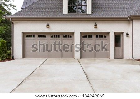 3-car garages with a long concrete driveway