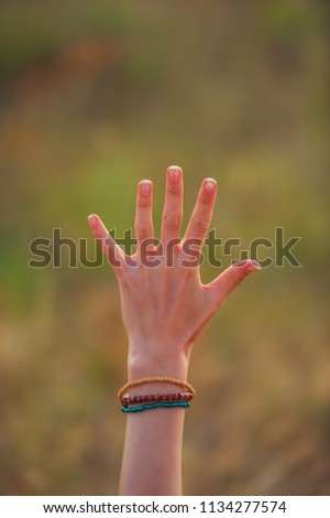 Hand on grass background. A woman's hand. The open palm of a woman