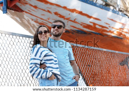 Young hipster couple in stylish jeans on pier