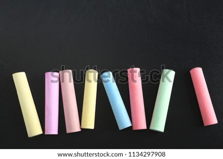 Color pieces of chalk on blackboard, top view