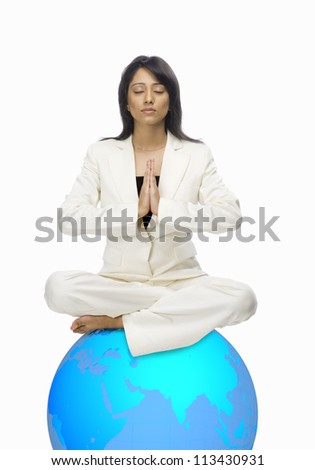 Businesswoman meditating on a globe