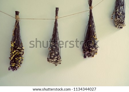 bouquet of dried flowers hanging on rope against wooden, decor wall backgrounde