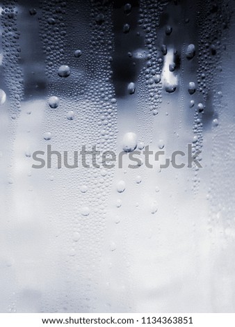 Cool water drops around the plastic bottles that look fresh. Dark background, dark and shining, light reflecting on the water droplets.