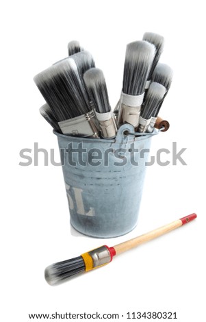 Paint brushes in bucket isolated over white