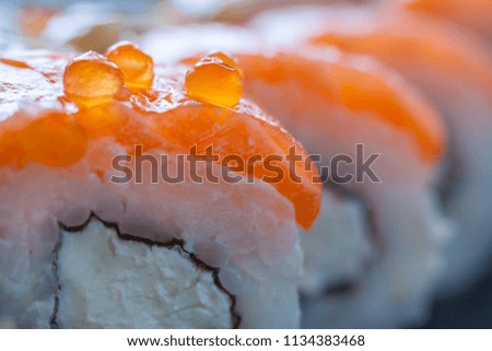 Close up view of a fragment of Philadelphia roll sushi with red caviar on top