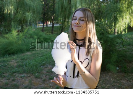 Girl eating Сotton Сandy in the park