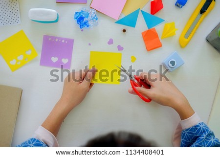 Female hands making paper art. Do it yourself concept