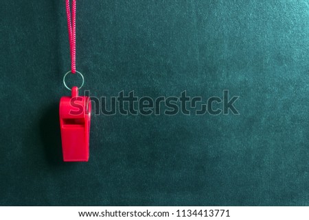 Sports whistle on a red lace.Concept- sport competition, referee, statistics, challenge, friendly match.Copy space. Royalty-Free Stock Photo #1134413771